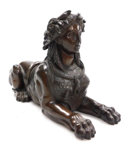 A late 19thC French hollow cast bronze of a sphinx, cast recumbent, with a woman's head bound with flowers and bull rushes, 26cm wide.