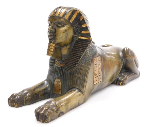 A 19thC polished bronzed figure of a sphinx, in recumbent pose, engraved with panels of hieroglyphics, 25cm wide.