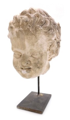 A 16thC carved stone head of an angel or putto, raised on a metal stand, 35cm high.