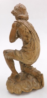 An 18thC German pine figure of a saint, carved in kneeling pose, with his hands in prayer, raised on a cloud base, traces of pigment, 33cm high. - 2