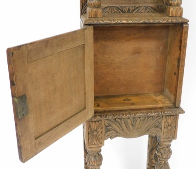 A late 19thC Jacobean style oak cupboard, of narrow proportions, with all over tree and foliate carving, the outswept pediment above a panelled back, raised on turned columns, over a cupboard enclosing a vacant interior, raised on a table base with cup an - 3