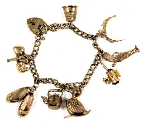 A 9ct gold charm bracelet, with eight charms as fitted, on a heart shaped padlock clasp, with safety chain, 18.0g all in.