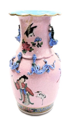 A Qing Dynasty 19thC pink ground baluster vase, of twin handled form, carved with lizards and dogs of Fo, painted with figures, birds and butterflies, against a pink ground incised with scrolling leaves, 34cm high. (AF)