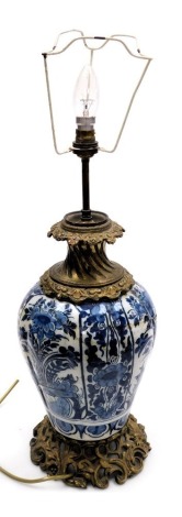 An 18thC Dutch Delft blue and white vase, converted to a table lamp, of vertical fluted form, painted with panels of flowers, with gilt metal mounts, 62cm high. (AF)