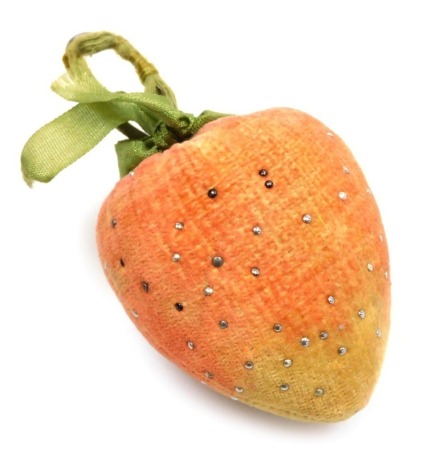 An Edwardian velvet and fabric pin cushion, modelled as a strawberry, set with pins, 10.5cm high.