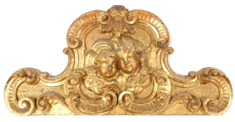 A 19thC Continental parcel gilt architectural pediment, carved with cherubs and rococo scrolls, 29cm x 58cm.