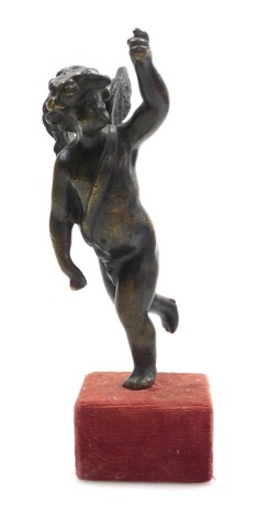 An 18thC bronze figure of a putto, modelled standing with his arm outstretched, raised on a velvet covered wooden block, 18.5cm high.