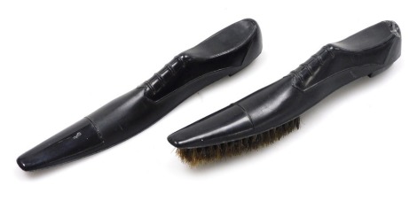 An early 20thC novelty black plastic shoe horn and brush set, modelled as lace up Oxford shoes, 19cm wide.