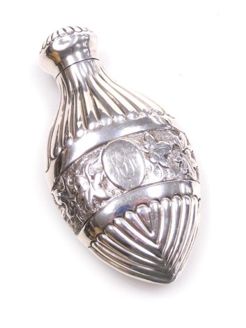 A Victorian silver scent bottle, of fluted flask form, with an embossed and engraved central band of leaves, oval reserve, monogram engraved, maker's mark worn, London 1886, 2.84oz all in, 9.5cm high.