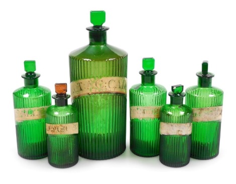 Six Victorian green glass apothecary bottles, various sizes, bearing traces of labels, largest bottle, 26cm high.