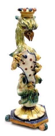 A late 19thC Cantagalli maiolica griffin figural candlestick, holding a spotted shield, raised on a triform base, 31cm high. (AF)