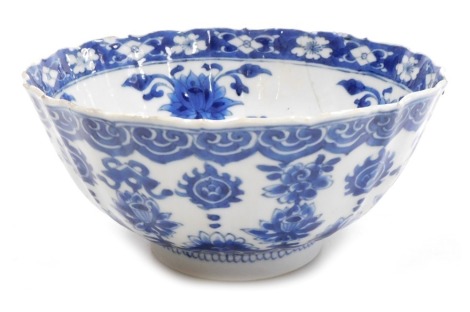 A Kangxi early 18thC blue and white Chinese porcelain bowl, of fluted form, decorated with flowers and Buddhist emblems within cloud borders, internally with flowers, impressed Manifest Happy mark, 19cm wide. (AF)