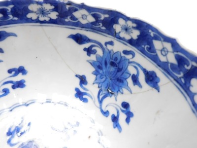 A Kangxi early 18thC blue and white Chinese porcelain bowl, of fluted form, decorated with flowers and Buddhist emblems within cloud borders, internally with flowers, impressed Manifest Happy mark, 19cm wide. (AF) - 4