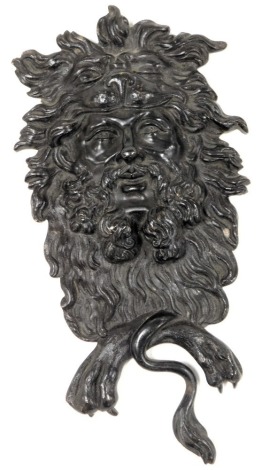 A mid 19thC cast iron mask plaque, showing the head of a beaded man, with lion's head helmet and mane, above crossed paws and tail, 22cm high.