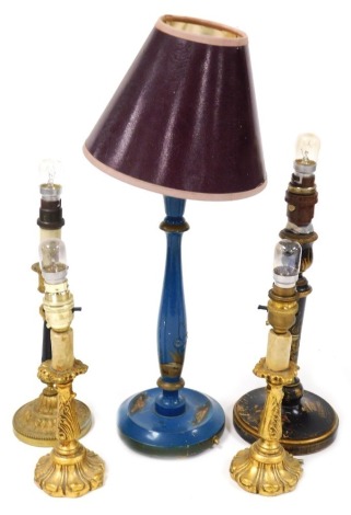 An early 20thC blue japanned lacquer table lamp, a black and gilt lacquer table lamp, a pair of gilt wood candle lamps, and a continental brass and plastic candlestick, converted to a table lamp. (4)