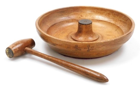 A mid 20thC Continental turned wooden nut bowl, with carved floral decoration, and a nut cracker of gavel form. (2)