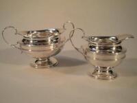 An Edwardian silver sugar bowl and cream jug engraved W. H. 1911