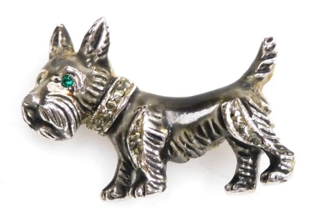 A 1950s Bohemian Jewellers Limited Scottie dog brooch, set with marcasites and emerald green and glass eyes, the body of white metal and enamel, 3cm wide.