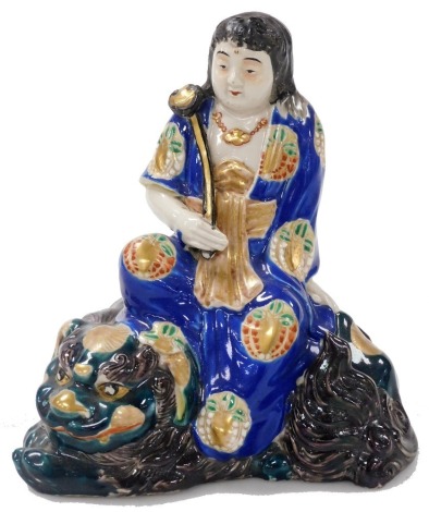 A Meiji period Japanese Kutani figure of Monju Bosatsu, seated on a shishi, and bearing a ruyi sceptre, 18cm high.