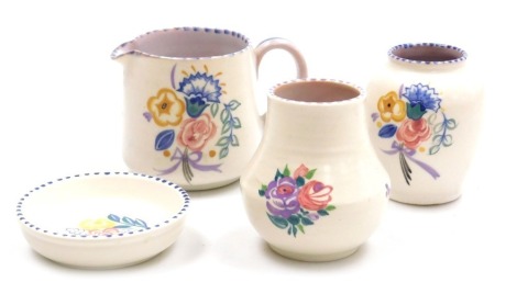 Four pieces of Poole pottery, traditionally painted with sprays of flowers, comprising a milk jug, 9.5cm high, two vases and a trinket dish, 10cm wide.