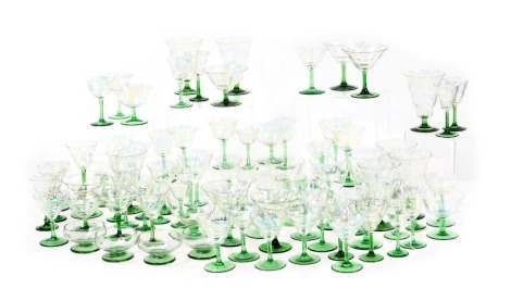 An early 20thC Continental lustre and green stemmed harlequin suite of table glassware, including champagne coupes, Martini glasses, liqueur glasses, wine glasses, etc. (a quantity)