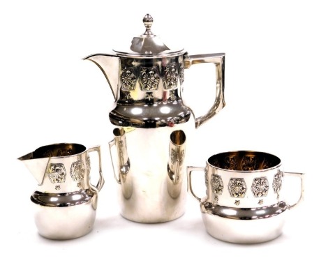 An early 20thC Continental silver plated three piece coffee set, embossed with a panel of stylised flowers, leaves and stars, comprising coffee pot, cream jug and sugar bowl.