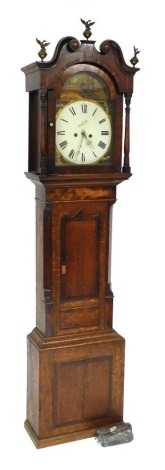 A Georgian mahogany and cross banded longcase clock, the break arch dial painted with a peacock and roses, circular dial bearing Roman numerals, subsidiary seconds dial, eight day two train movement, with bell strike, the break arch hood surmounted with b