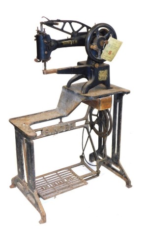 An early 20thC Singer model 29K58 cast iron treadle sewing machine, with instructions.