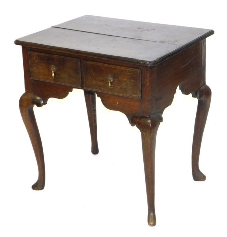 A George III oak lowboy, with two frieze drawers, raised on cabriole legs, 69cm high, 66cm wide, 51cm deep.