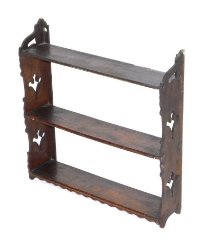 A 19thC oak hanging wall shelf, of three shelves, raised on carved ends, 51cm high, 50.5cm wide.