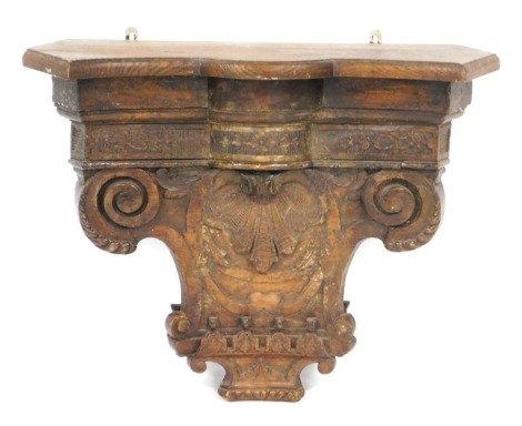 A 18thC Continental carved chestnut capital wall shelf or bracket, the capital engraved centrally with a scallop shell, beneath a frieze of harebells and other flowers, 63cm high, 78cm wide.