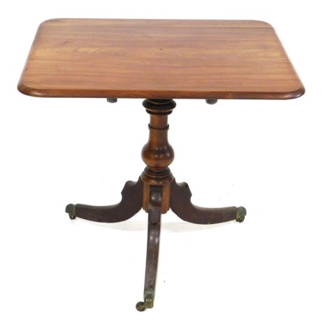 A George III mahogany tilt top occasional table, the rectangular top raised on a ring turned and vase shaped column over three outswept legs, brass capped on castors, 70cm high, 78cm wide, 67cm deep.