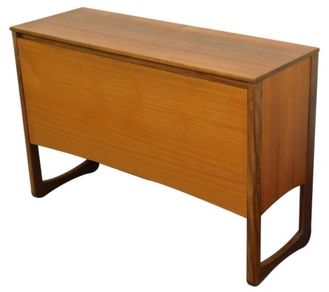 A mid century teak LP vinyl media cabinet, with a drop down front opening to reveal compartmentalized sections, raised on U shaped supports, 72cm high, 107cm wide, 37cm deep.