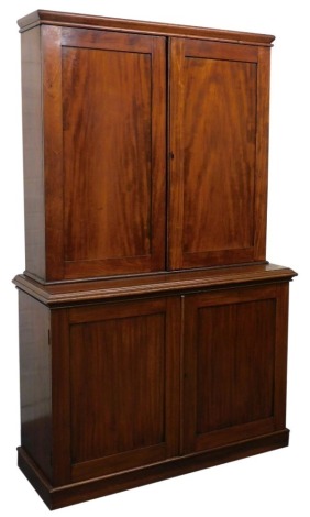 A Victorian mahogany housekeeper's cupboard, the outswept pediment over a pair of doors opening to reveal four shelves with three frieze drawers below, over a lower section with two further cupboards doors, raised on a plinth base, 208cm high, 129cm wide,