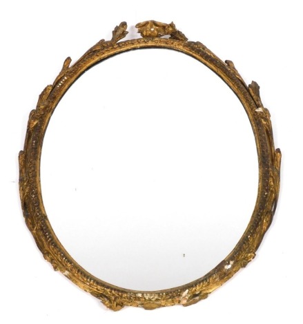 A late 18thC gesso oval wall mirror, with foliate carving, 83cm x 59cm. (AF)