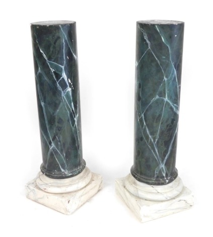 A pair of green faux marble plaster columns, raised on square plinth bases, 121cm high, 41cm diameter.