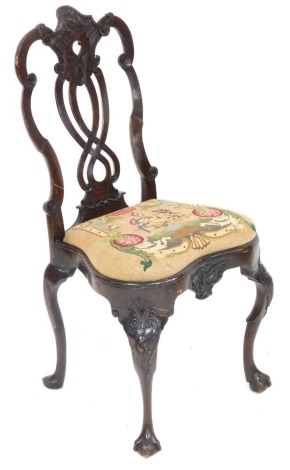 An 18thC Dutch walnut dining chair, with foliate carved and pierced splat, woolwork tapestry seat, raised on rococo foliate carved cabriole legs on ball and claw feet, 50cm wide.