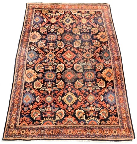 A Bidjar blue ground rug, decorated with medallions, flowers and scrolling leaves, within repeating floral borders, 310cm x 208cm.