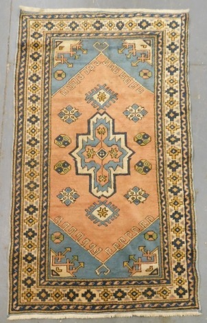 A Turkish red and turquoise ground rug, decorated with a central medallion surrounded by floral and geometric motifs, within repeating floral and foliate borders, 222cm x 122cm.