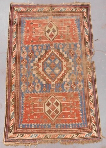 A Turkish blue ground rug, with a central geometric medallion, flanked by two rectangular medallions, filled with stylised flowers and geometric motifs, within repeating geometric borders, 194cm x 115cm.