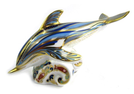 A Royal Crown Derby porcelain paperweight modelled as a dolphin, gold stopper and red printed marks, 10cm high.