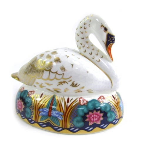 A Royal Crown Derby porcelain paperweight modelled as a swan, silver stopper and red printed marks, 11cm high.