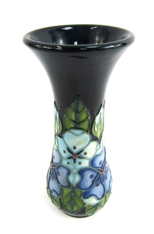 A Moorcroft stem vase, on a blue ground, decorated in the Cobridge Cobalt Blue pattern, stamped to underside, 12cm high.