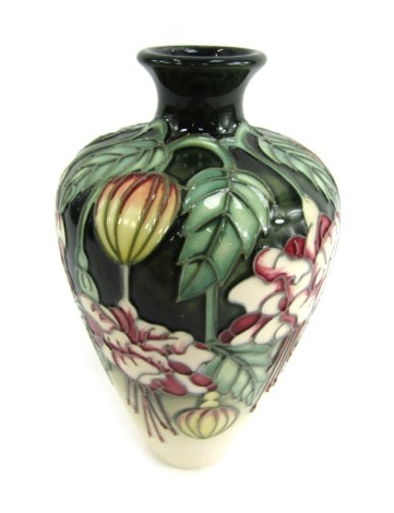 A Moorcroft squat vase, on a green and cream ground, in the Cottage pattern, indistinctly signed in gold and numbered 29/300, 16cm high.