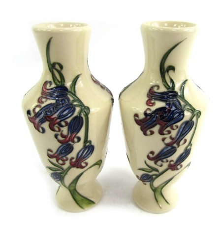 A pair of Moorcroft stem vases, each on a cream ground, in the Bluebell Harmony pattern, dated 2009 and stamped to underside, 15.5cm high. (2)