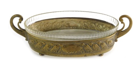 A WMF two handled serving dish, of oval form decorated with embossed flowers, cartouche and lower banded hammered decoration, with glass liner, stamped to underside, 38cm wide overall.