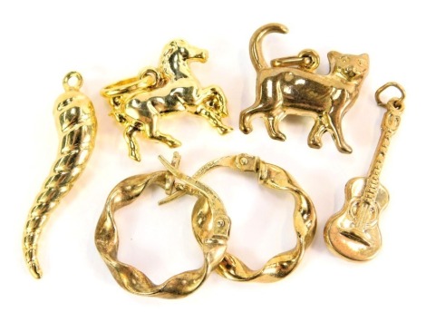 A pair of 9ct gold twist hoop earrings, and a selection of unmarked yellow metal charms, to include horn, horse, guitar, and cat, 3.9g all in.