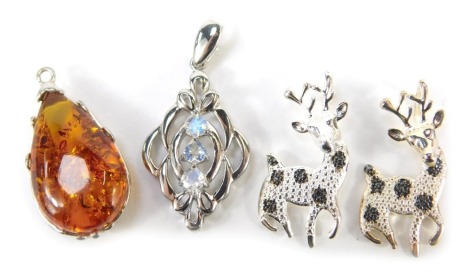 Four TJC pendants, comprising two black diamond deer, white metal stamped 925, a Baltic amber pendant, and a further silver example set with cz stones, with two TJC bags. (4)