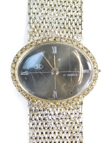 A JNF lady's fashion watch, the oval dial with silvered finish and four point Roman numerals, with seventeen jewel movement, on plated strap.