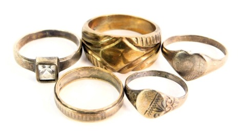 A group of assorted dress rings, comprising three white metal dress rings, unmarked, a white and yellow metal 9ct gold and silver wedding band, 7.5g all in, and a copper dress ring. (5)